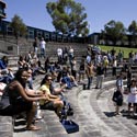 Group of students sitting and standing around a bluestone amphitheatre